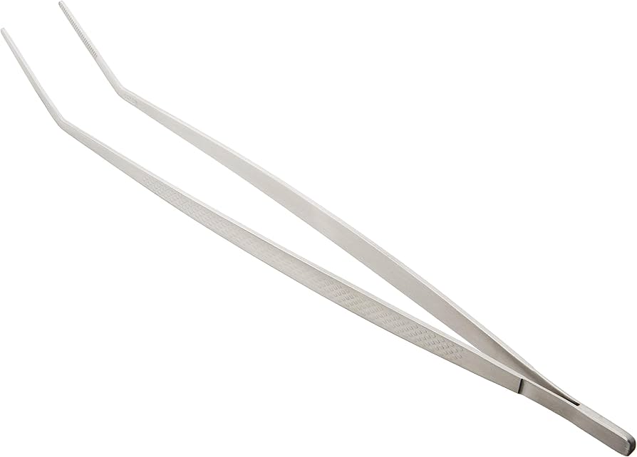 A close-up photo of fine-tip tweezers, a bar of soap, a small bowl of warm water, and a clean washcloth laid out on a bathroom counter