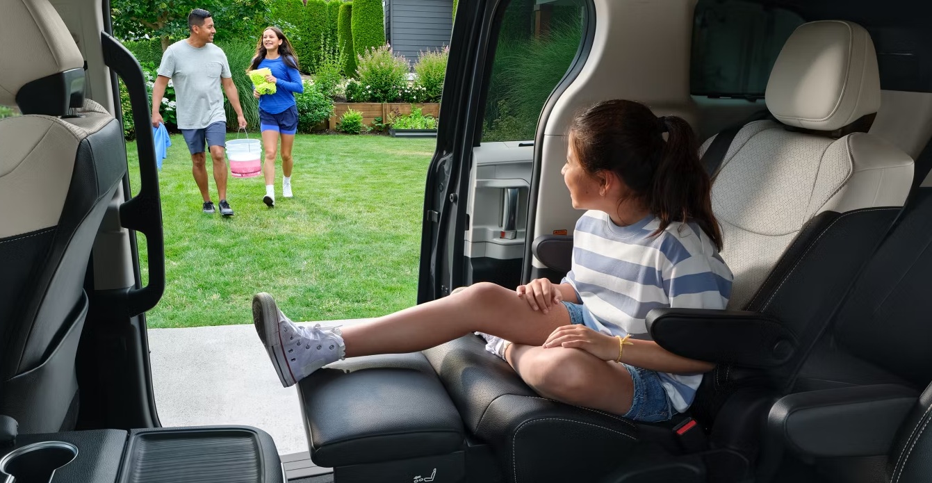 A parent adjusting a child car seat chest clip to armpit level while the child wears a thin fleece, close-up real photo
