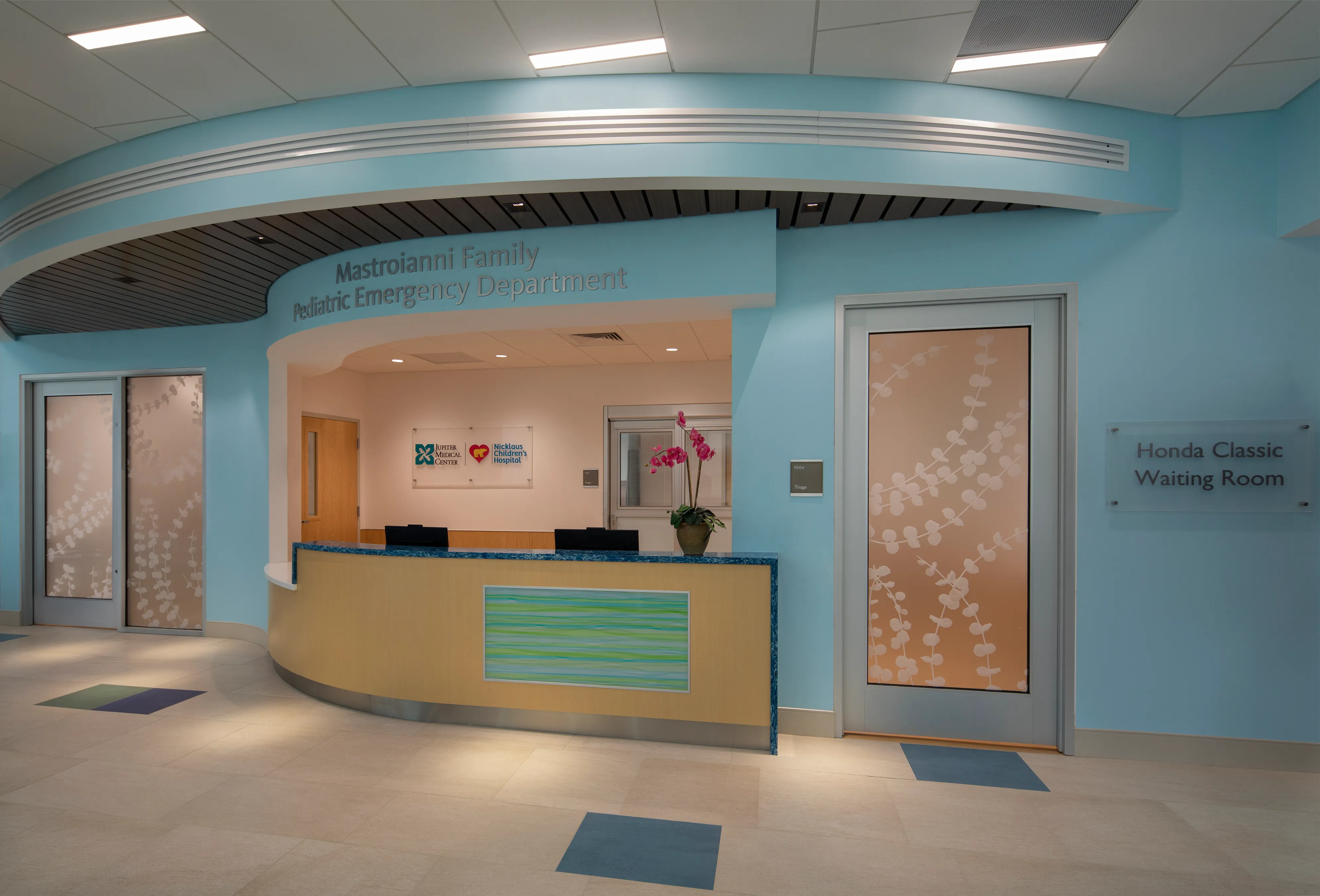 A parent holding a sleepy child in a pediatric emergency department waiting area, candid news-style photo with neutral lighting