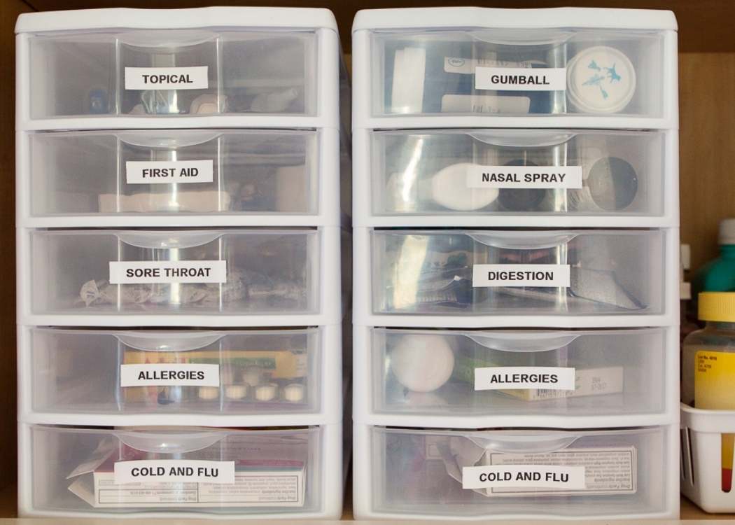 A parent organizing over-the-counter allergy medicine in a bathroom medicine cabinet