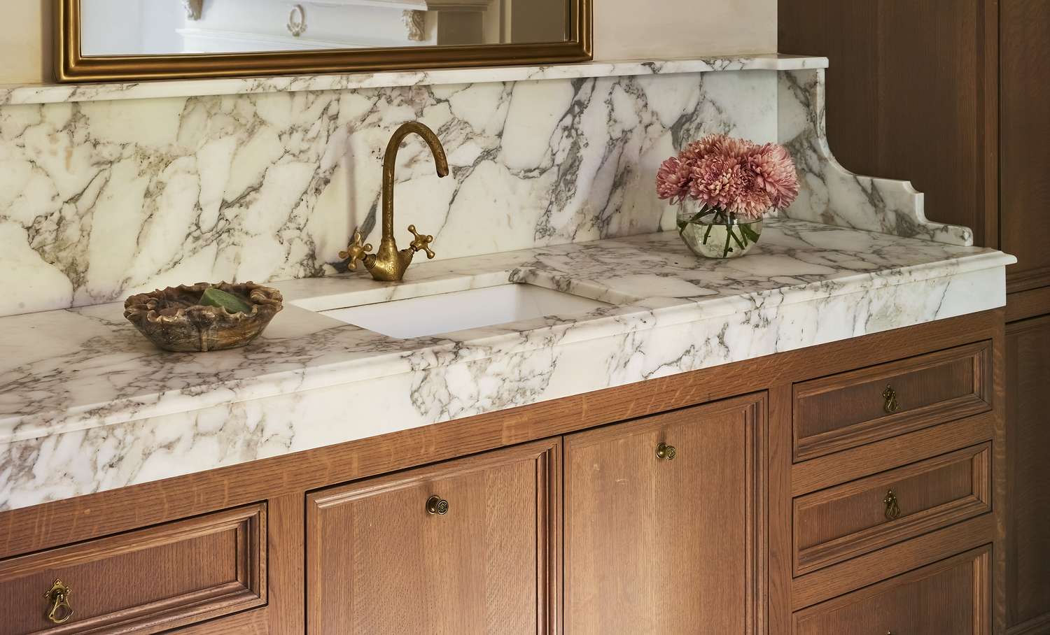 A parent parting a young child’s hair in a home bathroom to look at a small circular scaly patch on the scalp, realistic photograph