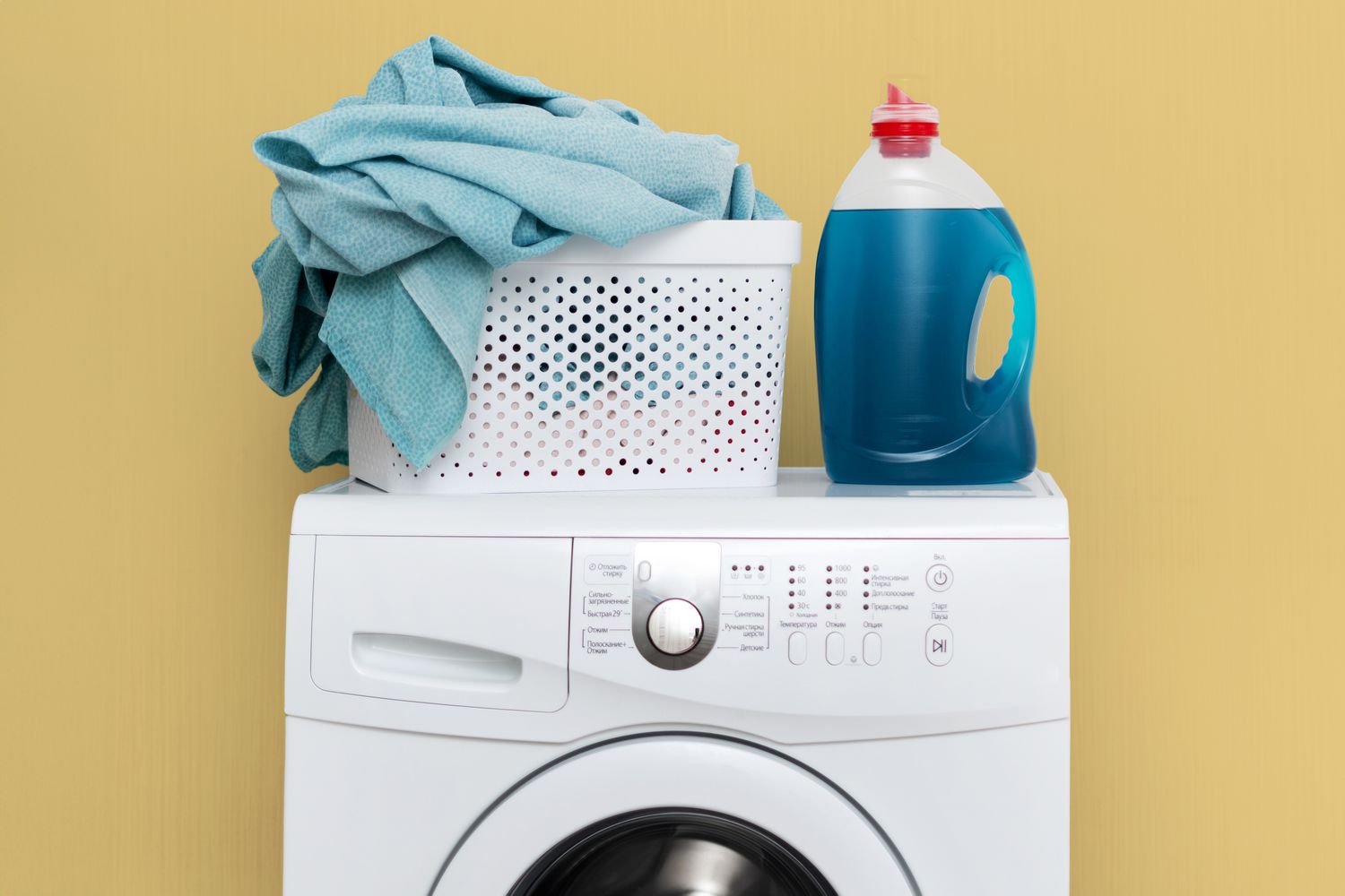 A parent placing children’s bedding into a washing machine in a home laundry room, realistic photo