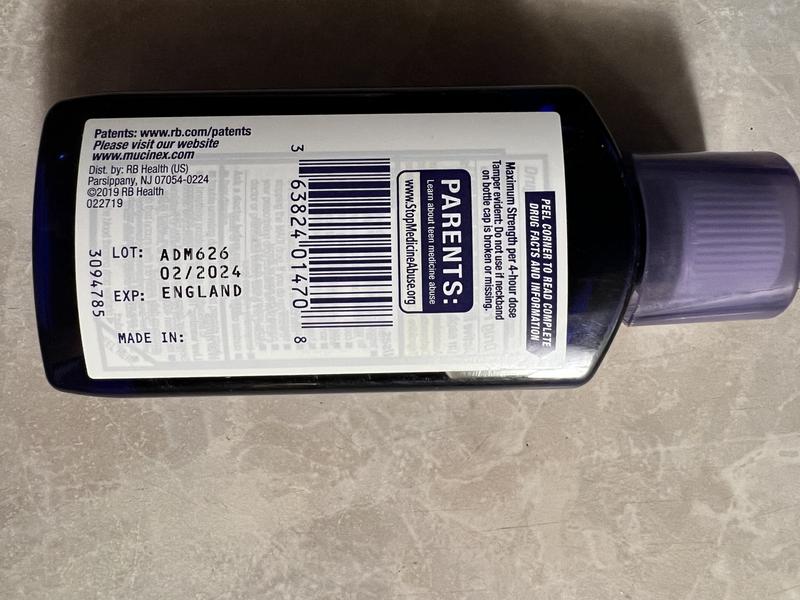 A parent reading the Drug Facts label on an over-the-counter medicine while looking for the lot number, NDC, and expiration date