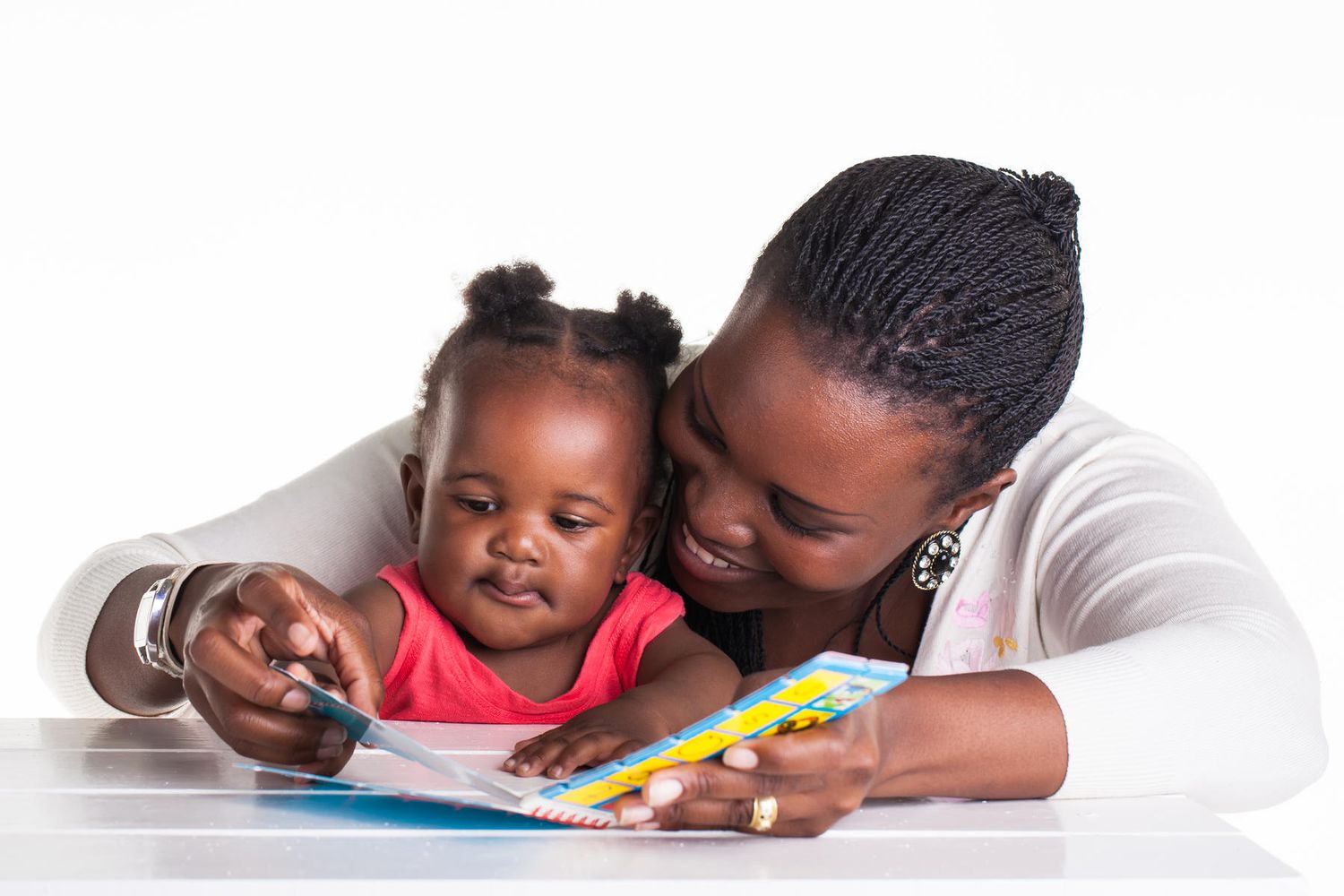 A parent sitting beside a crib reading a bedtime book to a 10-month-old baby in a calm, softly lit nursery, realistic photograph