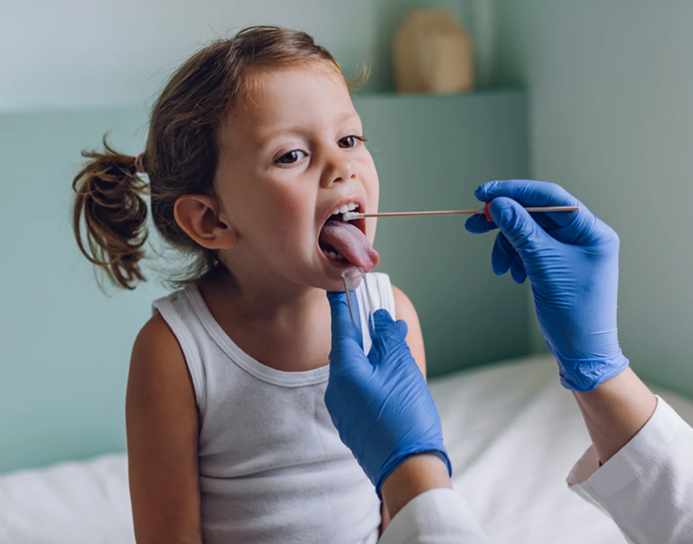 A pediatric clinician gently swabbing a school-aged child’s throat in an exam room while a parent stands nearby, realistic medical photo