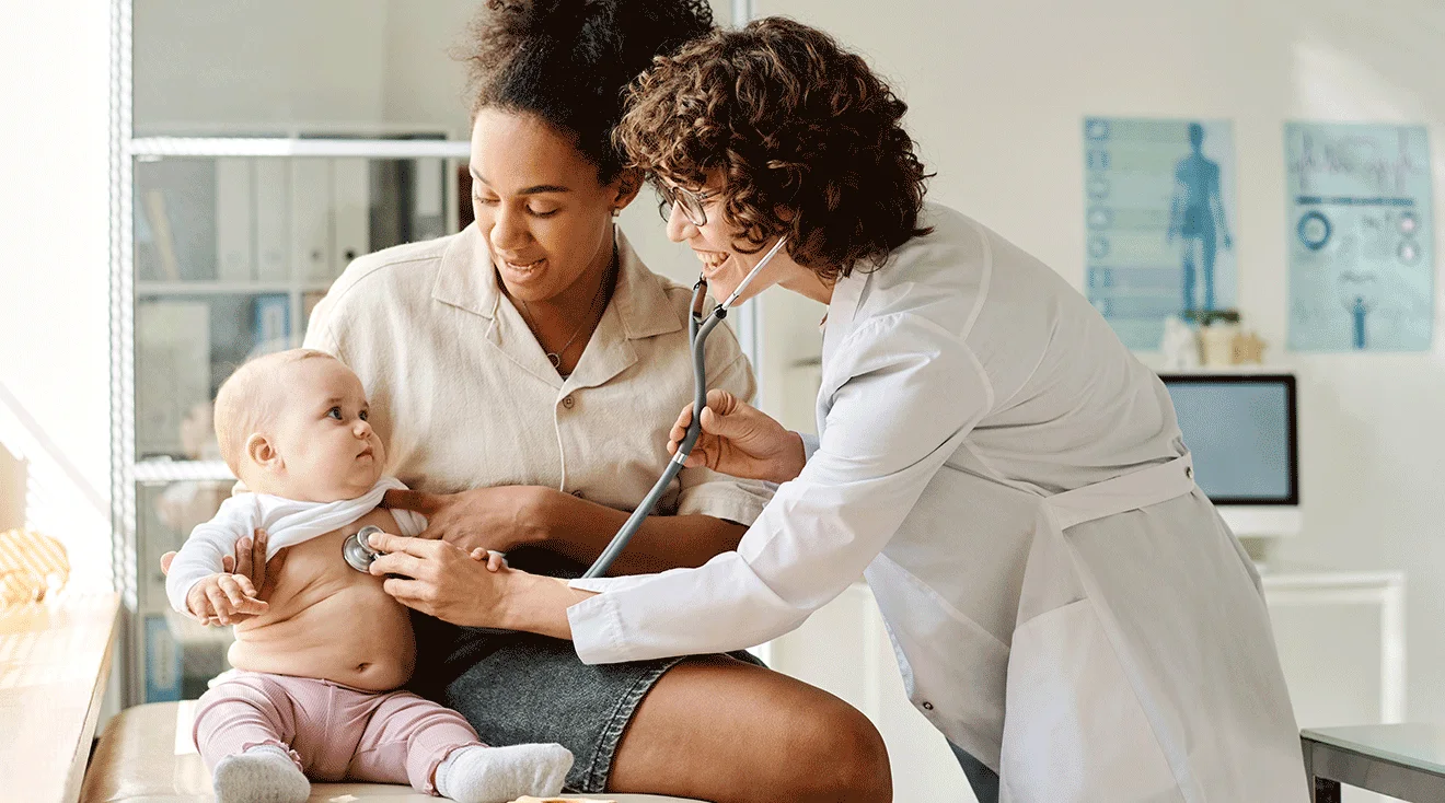 A pediatric clinician using a stethoscope to listen to a baby’s chest while the baby sits on a parent’s lap in a medical exam room, natural clinical lighting, realistic photography