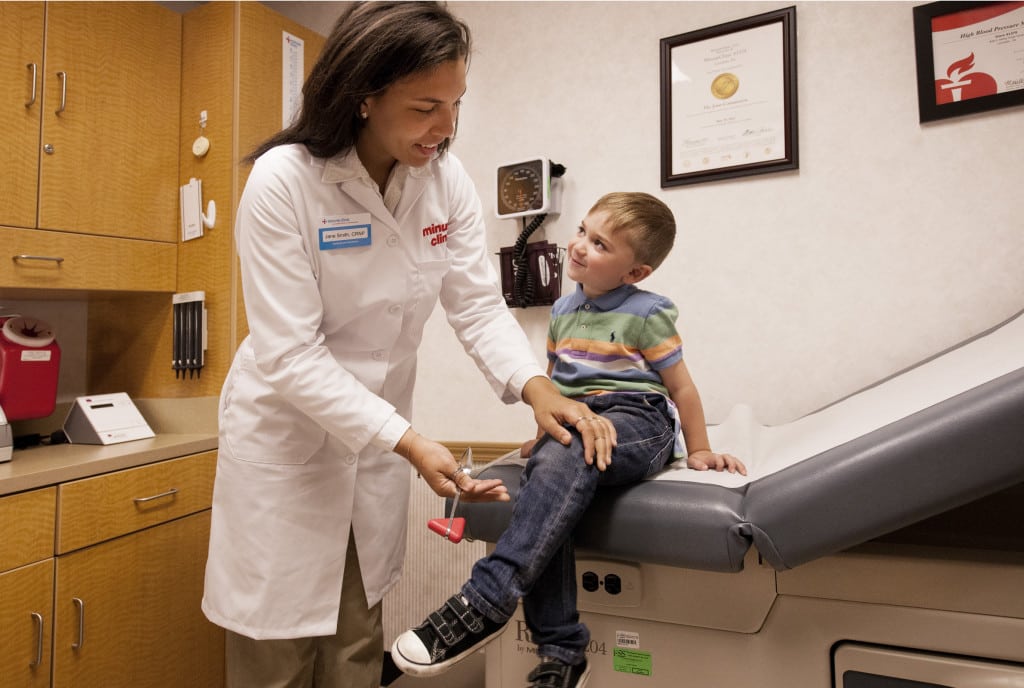 A pediatric nurse in a clinic gently examining a child’s upper arm rash while a parent stands nearby, candid medical photo style