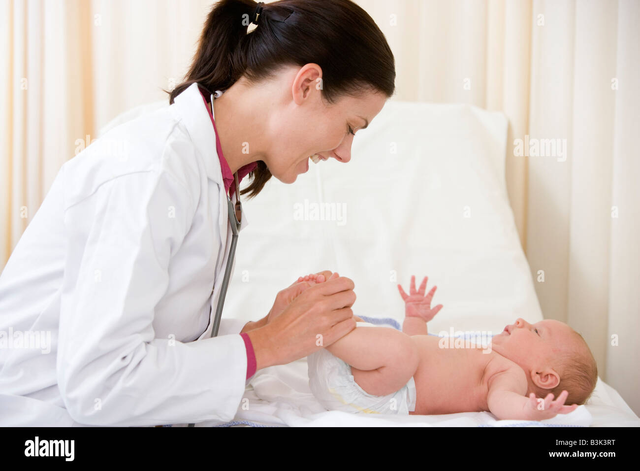A pediatrician gently examining a newborn during a well-baby visit in a clinic exam room while a parent watches nearby
