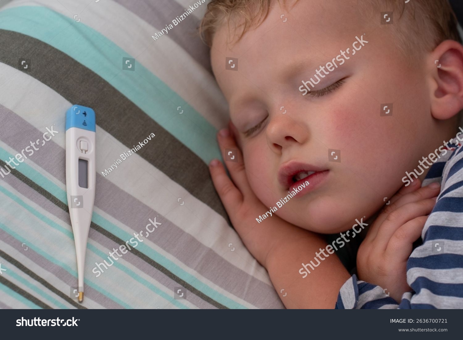 A preschool-aged child lying in bed holding a digital thermometer while a parent sits nearby, realistic indoor photo