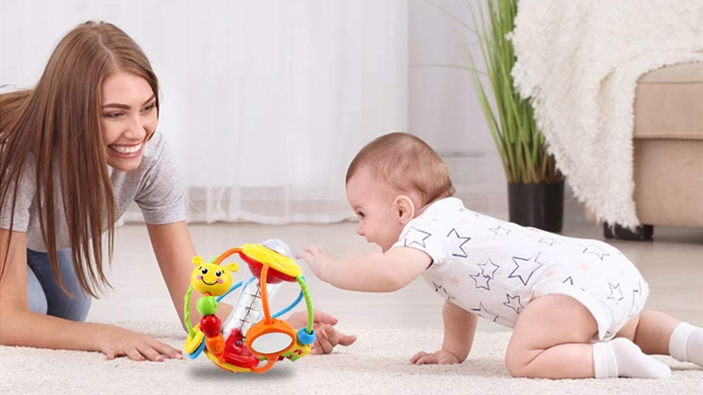 A preschool-aged child strapped into a car seat holding a small textured sensory ball with both hands, looking out the window, realistic candid photograph