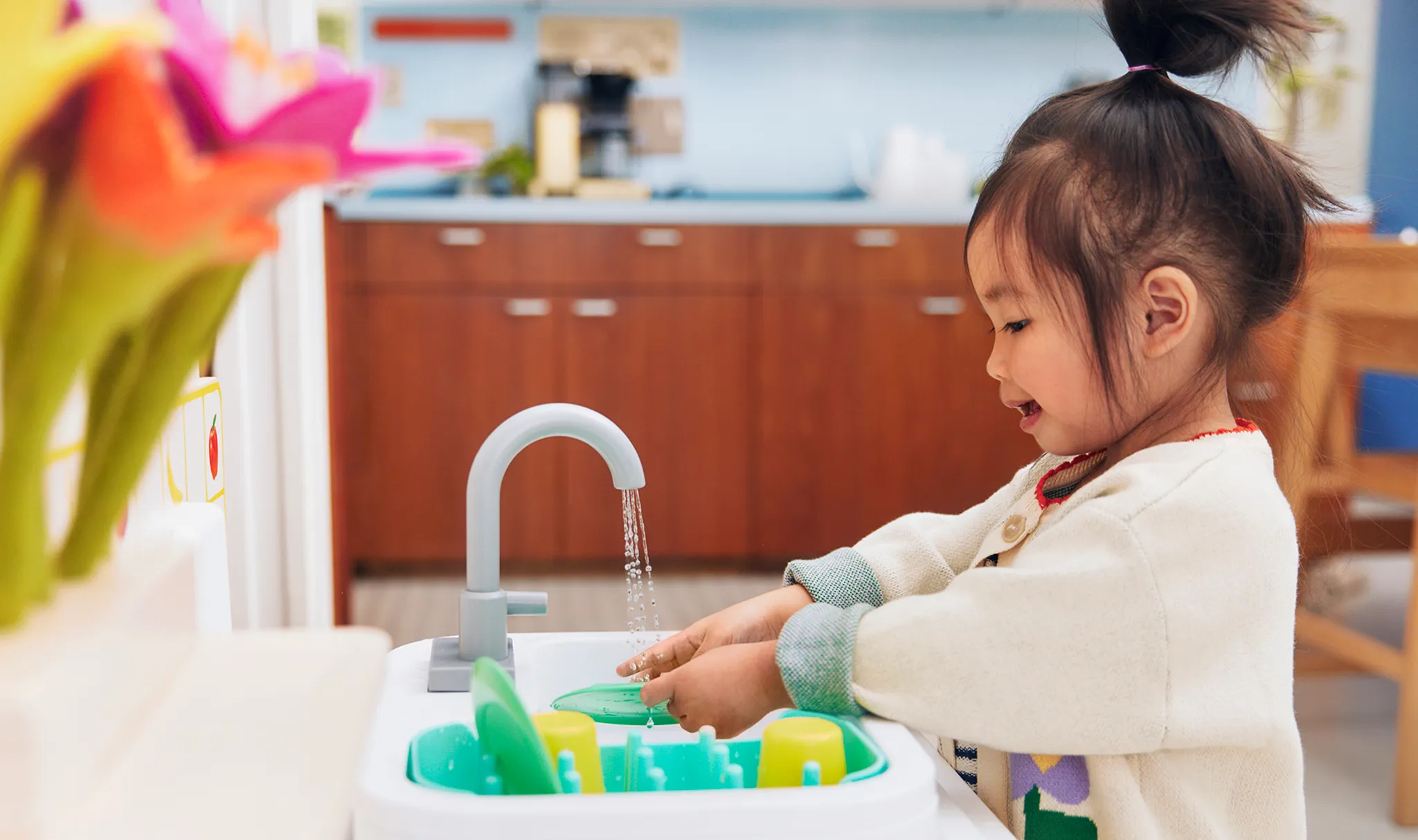 A real-life photo of a toddler in pajamas standing on a step stool at a kitchen sink, taking big gulps of water from a cup in soft morning light