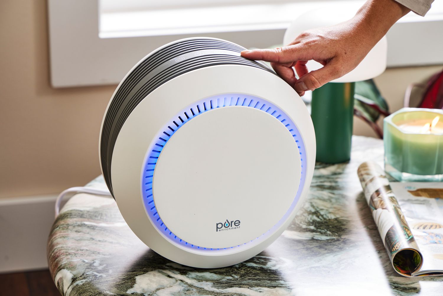 A real photo of a compact HEPA air purifier running on the floor of a child’s bedroom beside a small bed, soft natural light