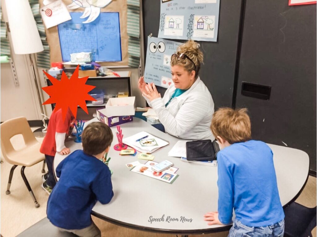 A speech-language therapist sitting at a small table with a kindergarten-aged child, using simple picture cards during a speech session