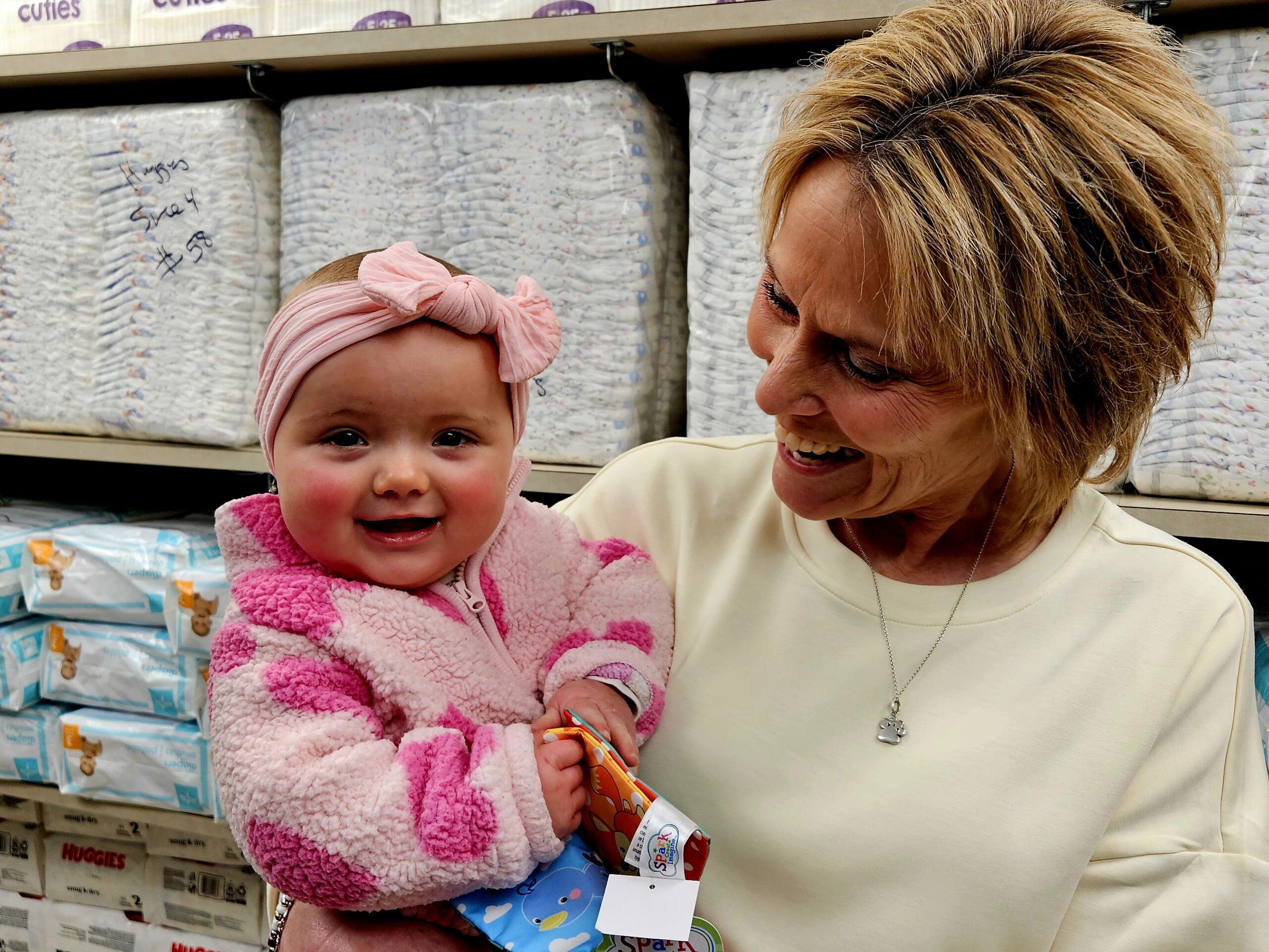 A tired parent in a softly lit nursery looking closely at a baby diaper on a changing table, realistic photo